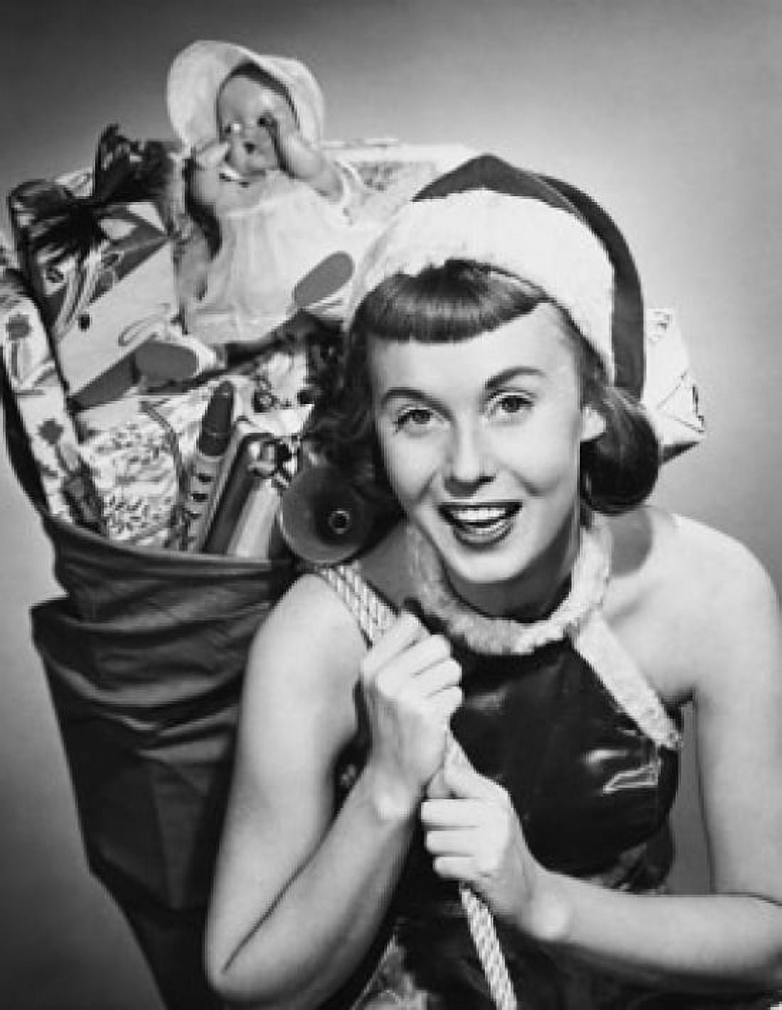 Portrait of a young woman carrying a sack of Christmas presents on her back Canvas Art - (18 x 24)