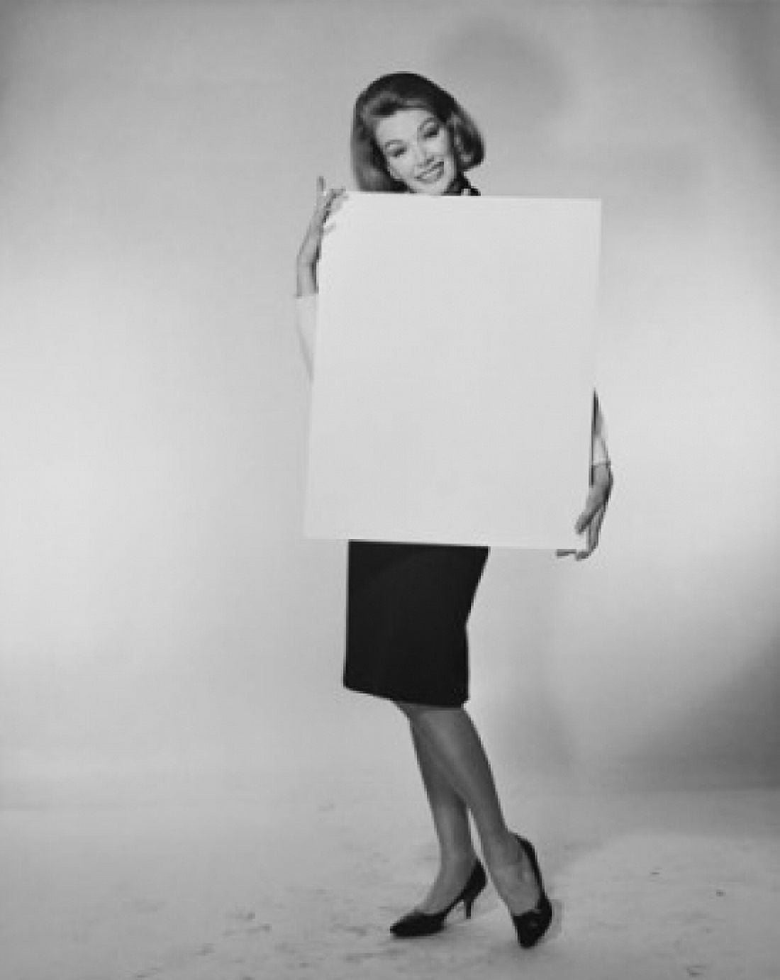 Portrait of a young woman holding a blank placard Canvas Art - (18 x 24)