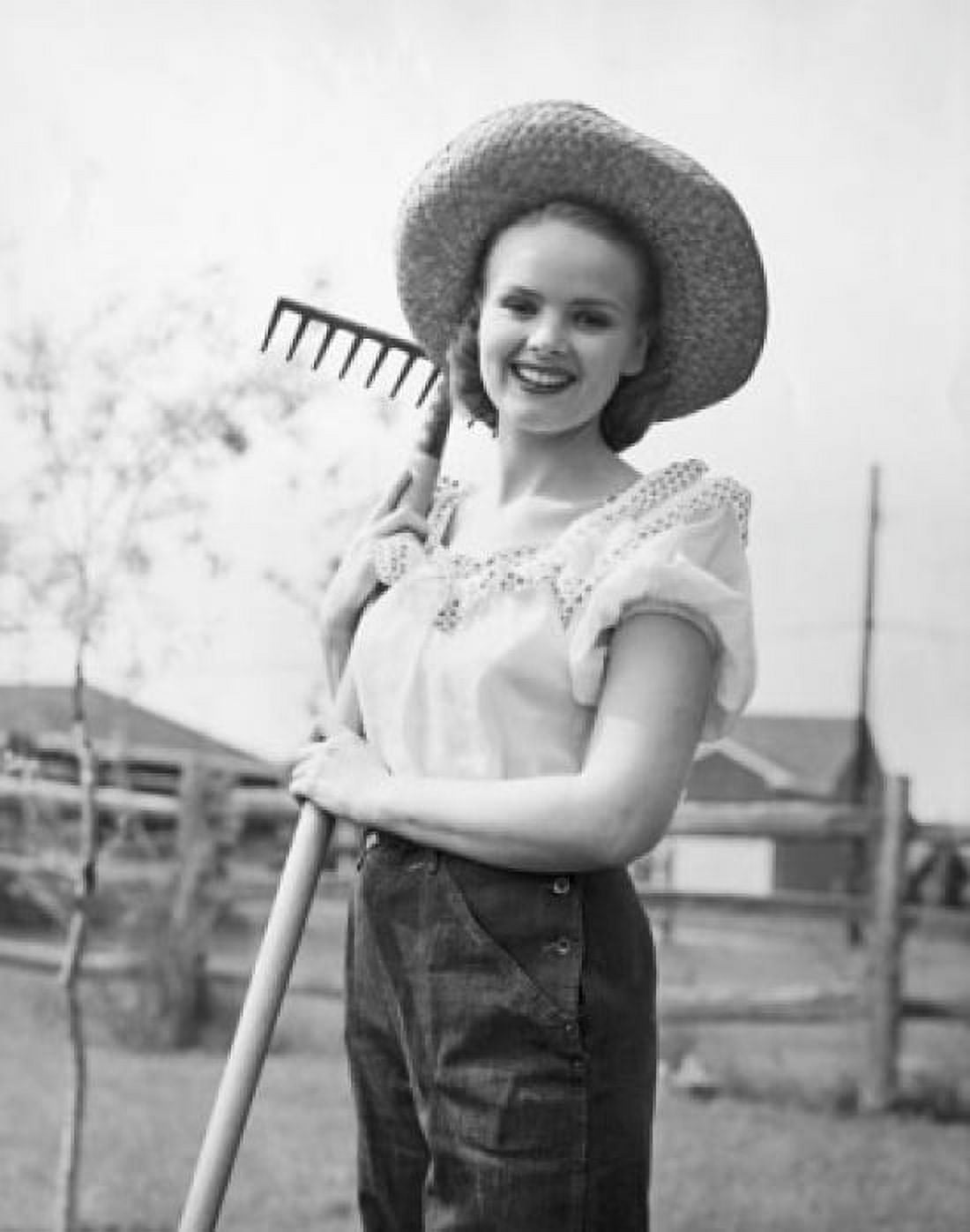 Portrait of a young woman holding a rake and smiling Canvas Art - (24 x 36)