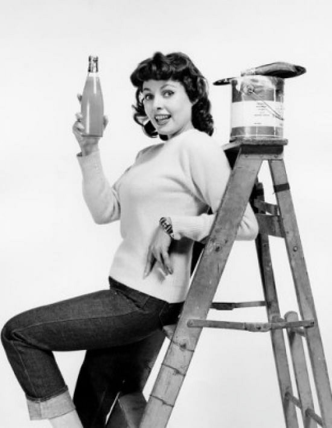 Portrait of a young woman leaning against a step ladder and holding a bottle Canvas Art - (18 x 24)