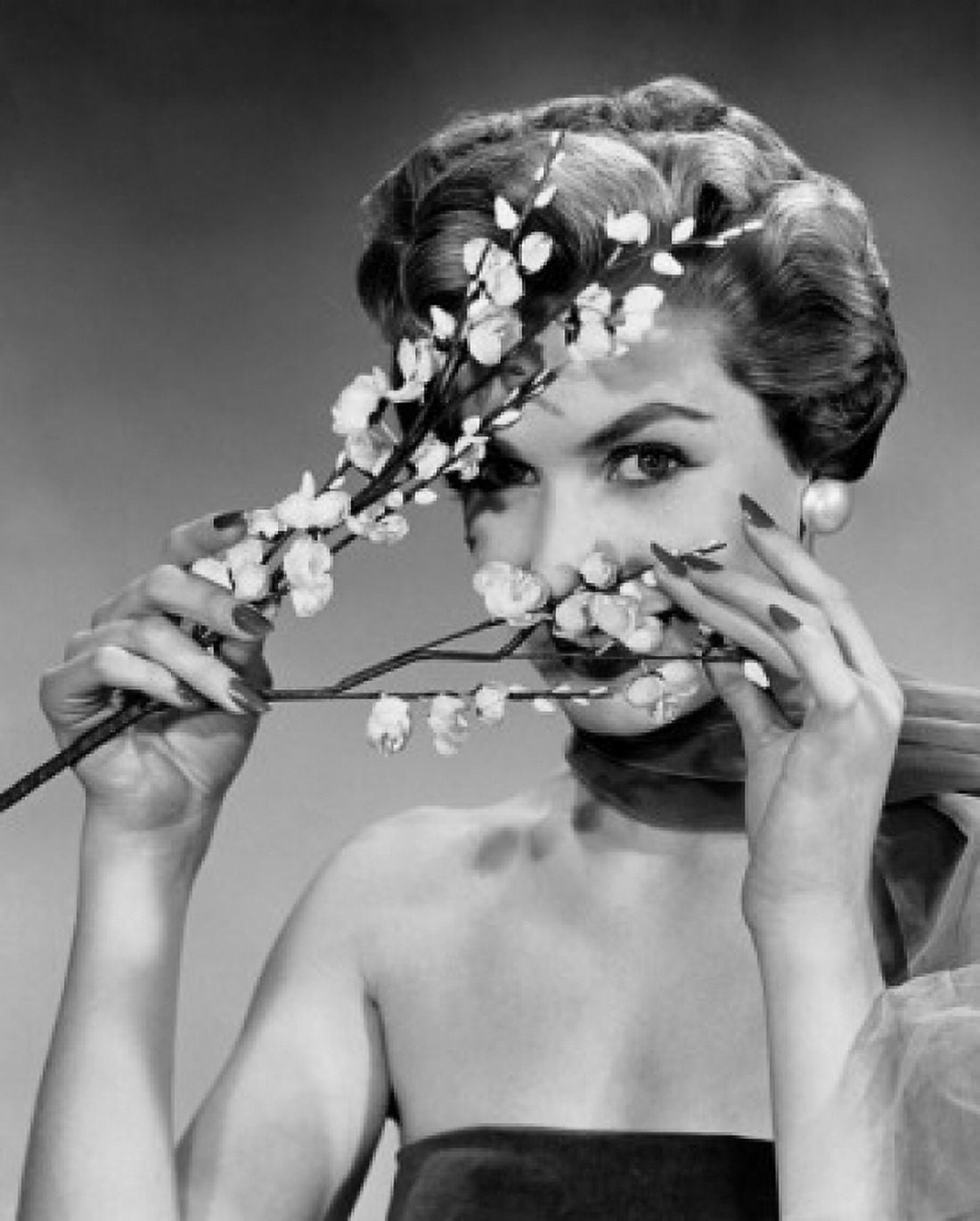 Portrait of a young woman peeking through flowers Canvas Art - (18 x 24)