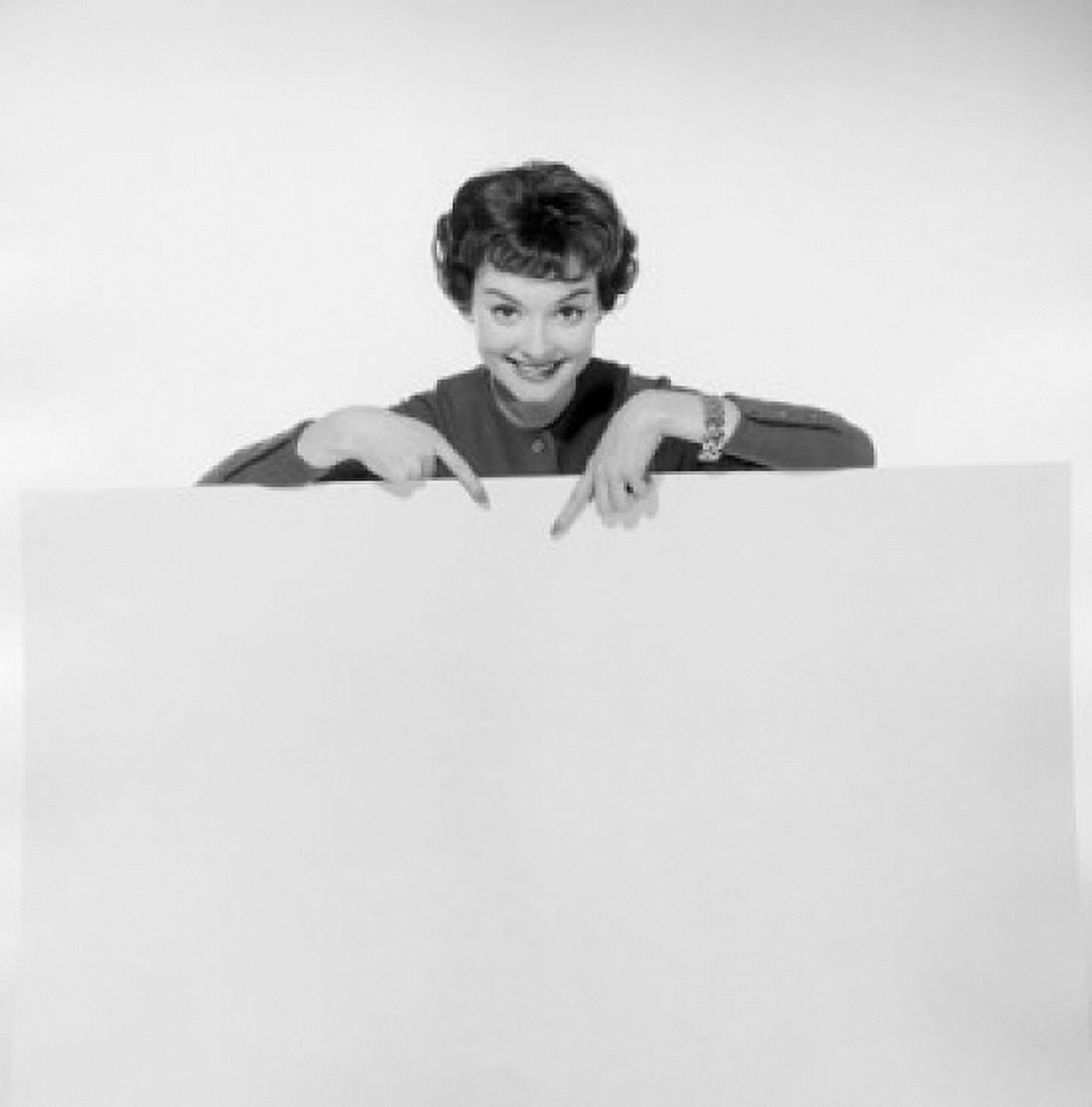Portrait of a young woman pointing to a blank placard Canvas Art - (24 x 36)