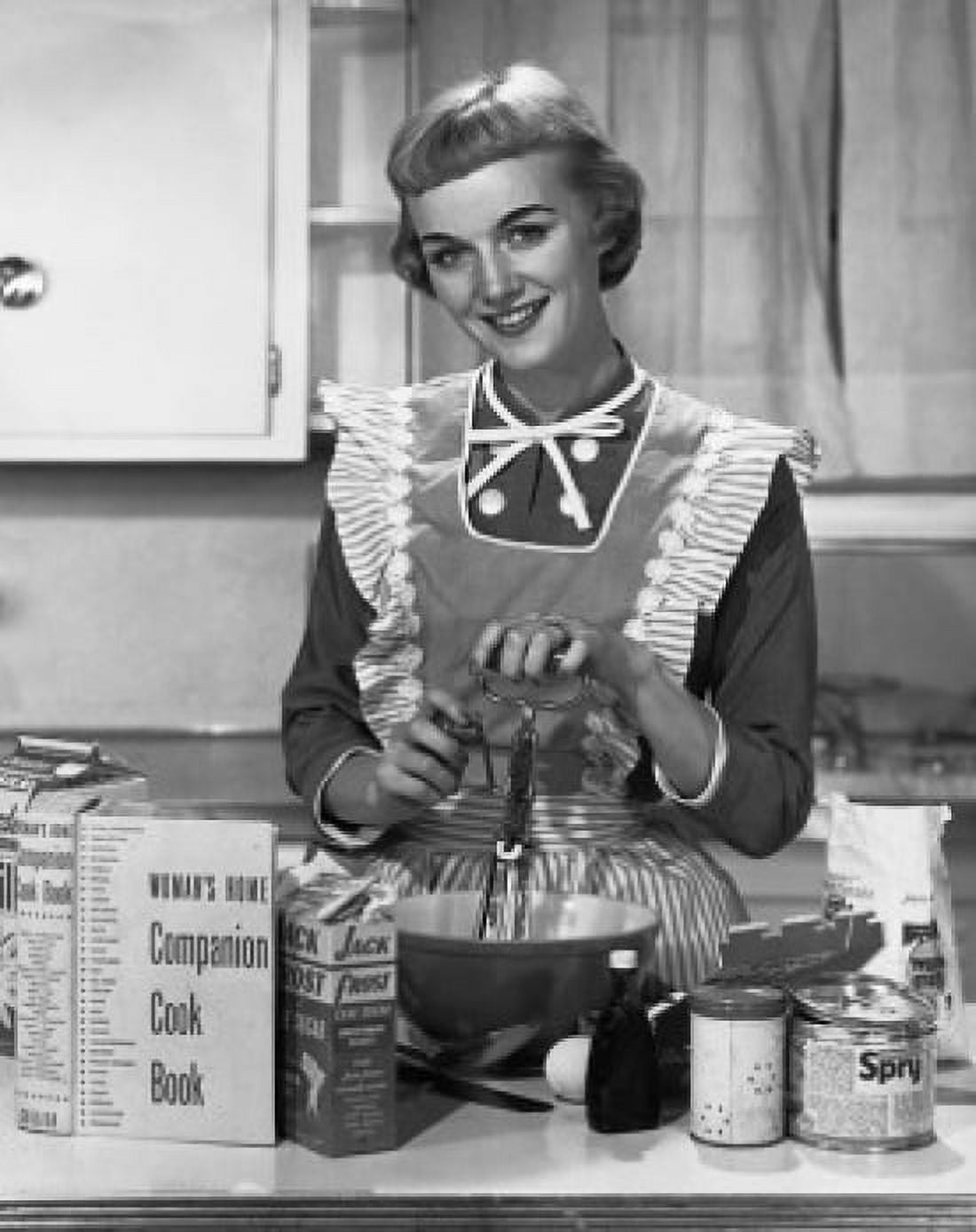 Portrait of a young woman preparing food in the kitchen and smiling Canvas Art - (24 x 36)