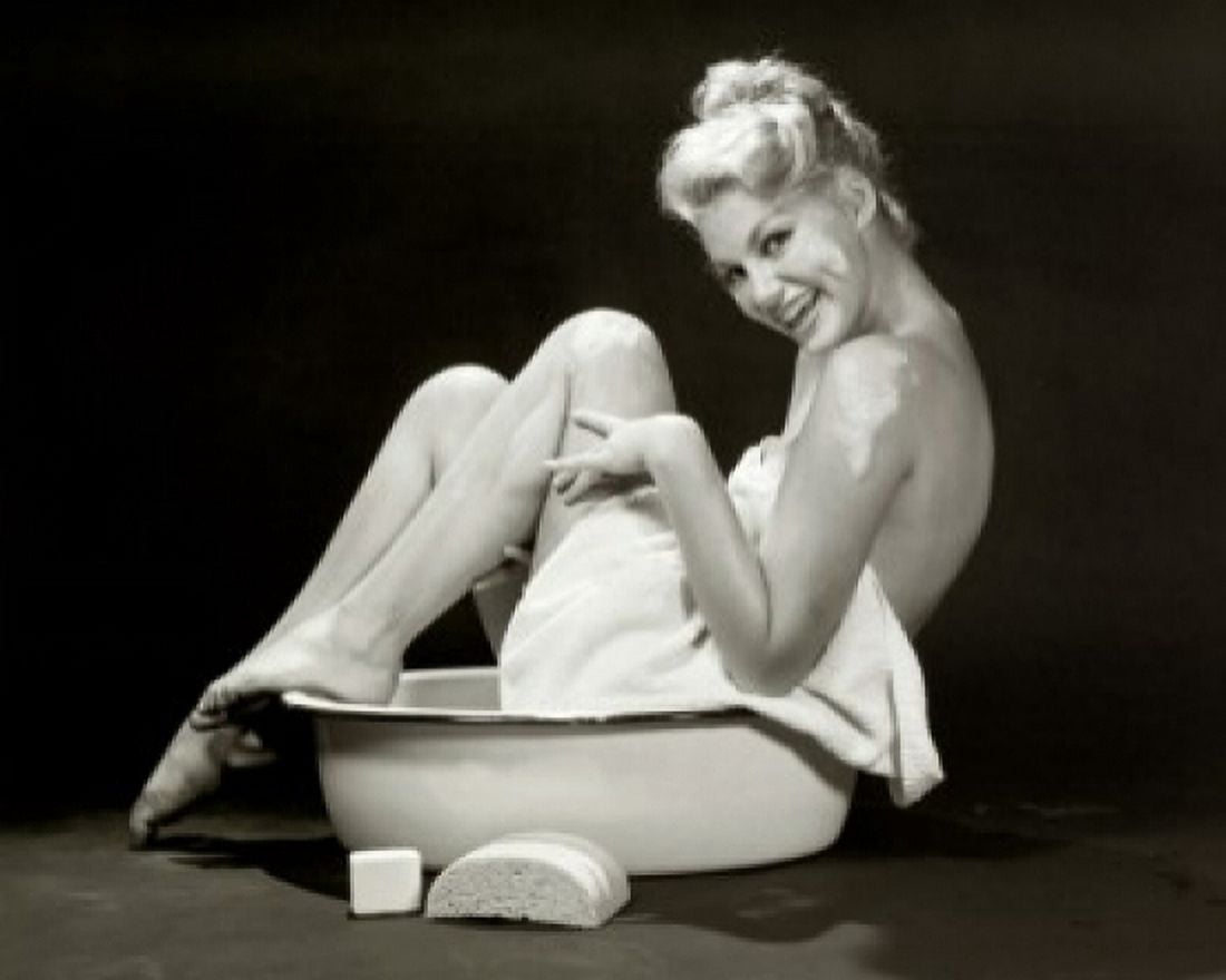 Portrait of a young woman sitting in a bathtub laughing Canvas Art - (24 x 36)