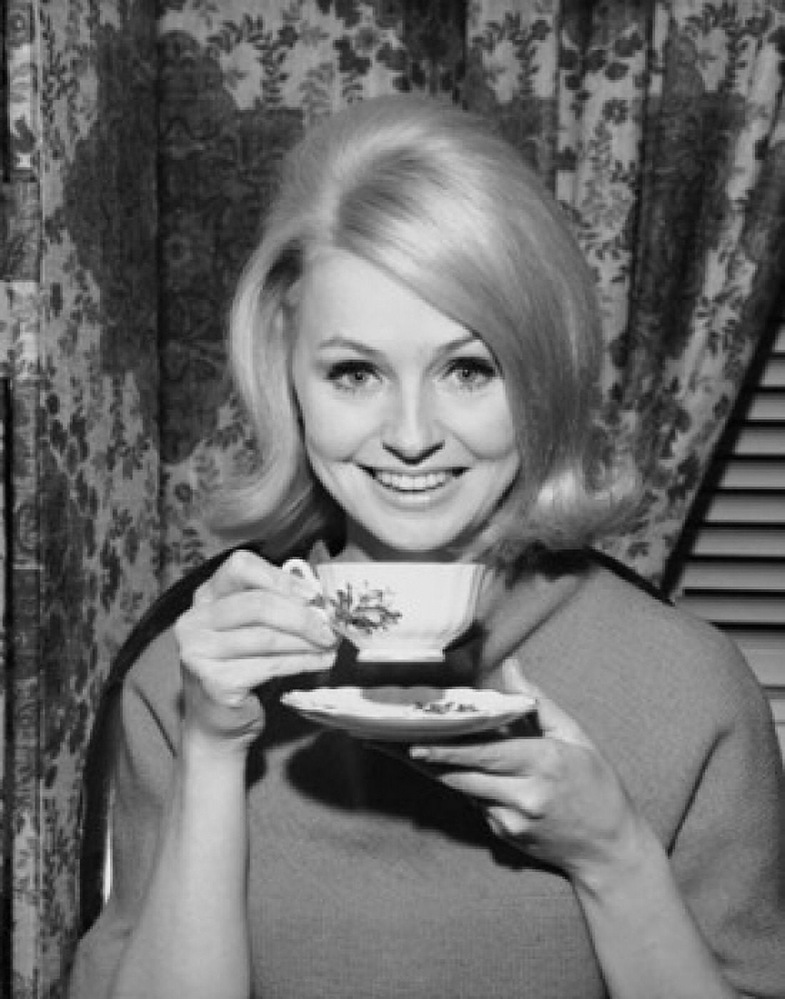 Portrait of a young woman smiling and holding a tea cup Canvas Art - (24 x 36)