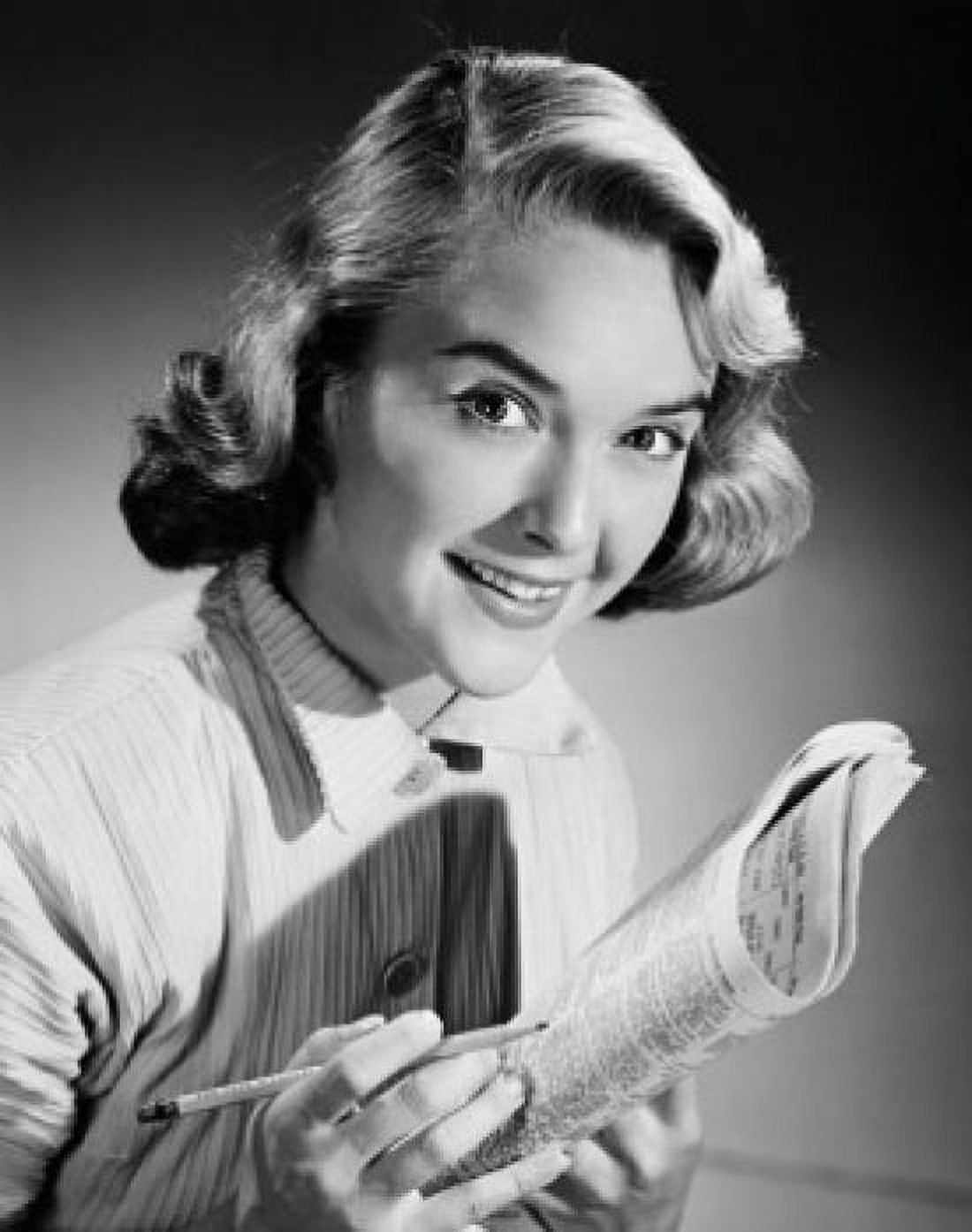 Portrait of a young woman smiling holding a newspaper Canvas Art - (18 x 24)