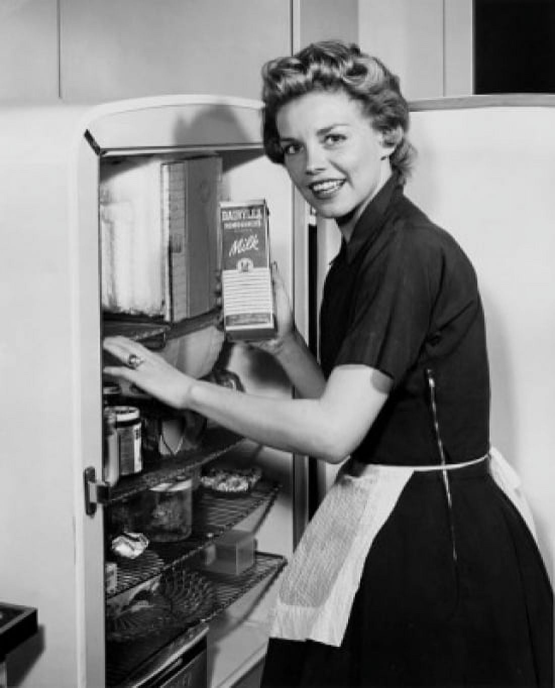 Portrait of a young woman standing near a refrigerator Canvas Art - (24 x 36)