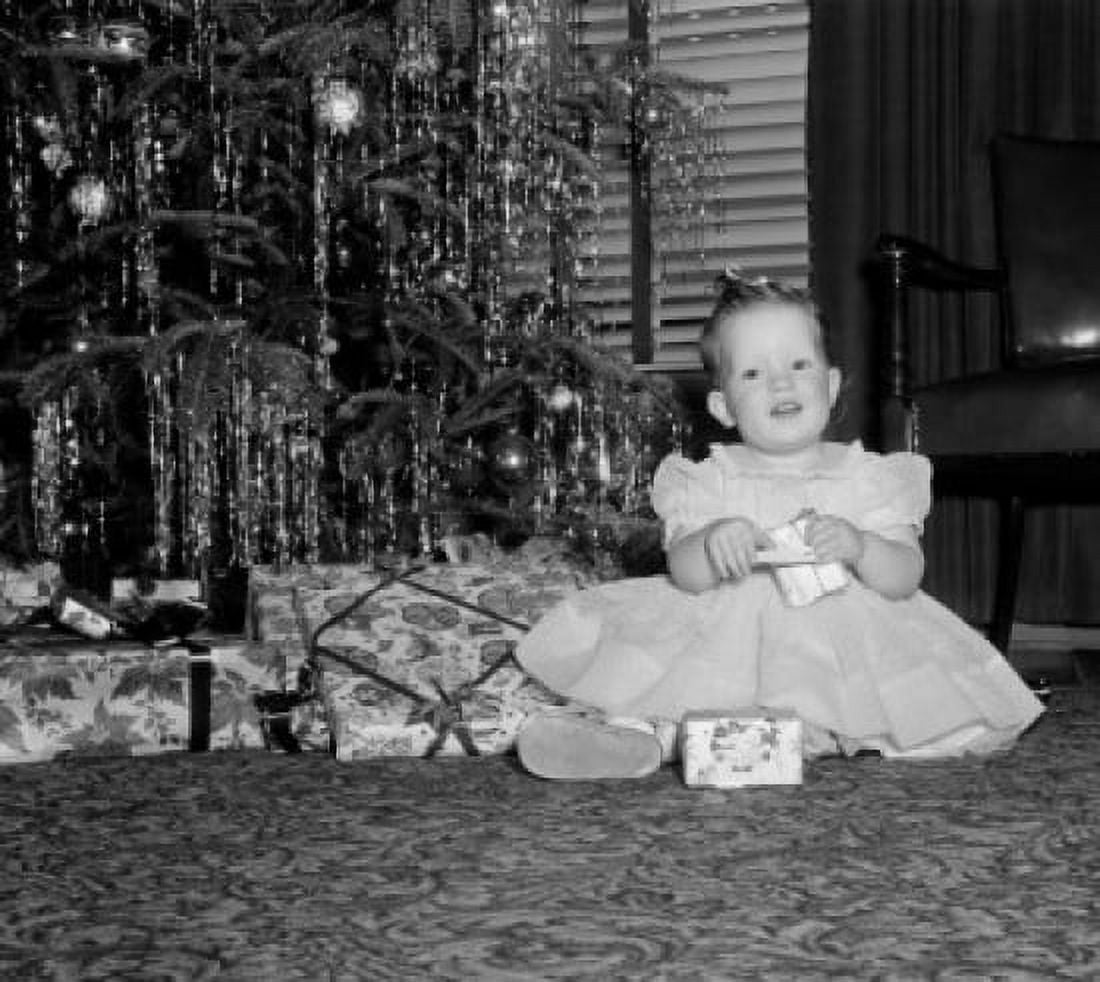 Portrait of baby girl holding gifts by Christmas tree Canvas Art - (24 x 36)