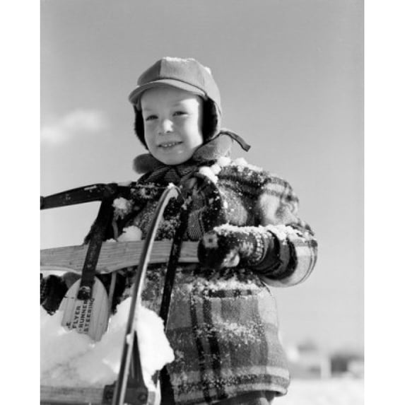 Portrait of boy covered with snow, holding sleigh Poster Print (24 x 36)