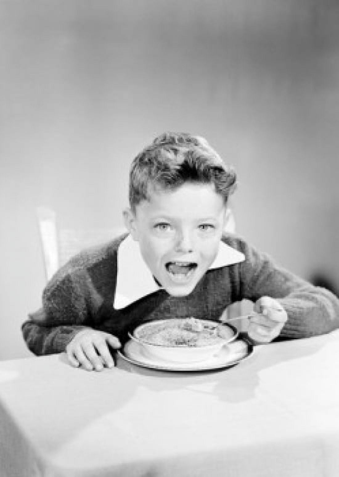 Portrait of boy eating breakfast cereal at table Canvas Art - (24 x 36)