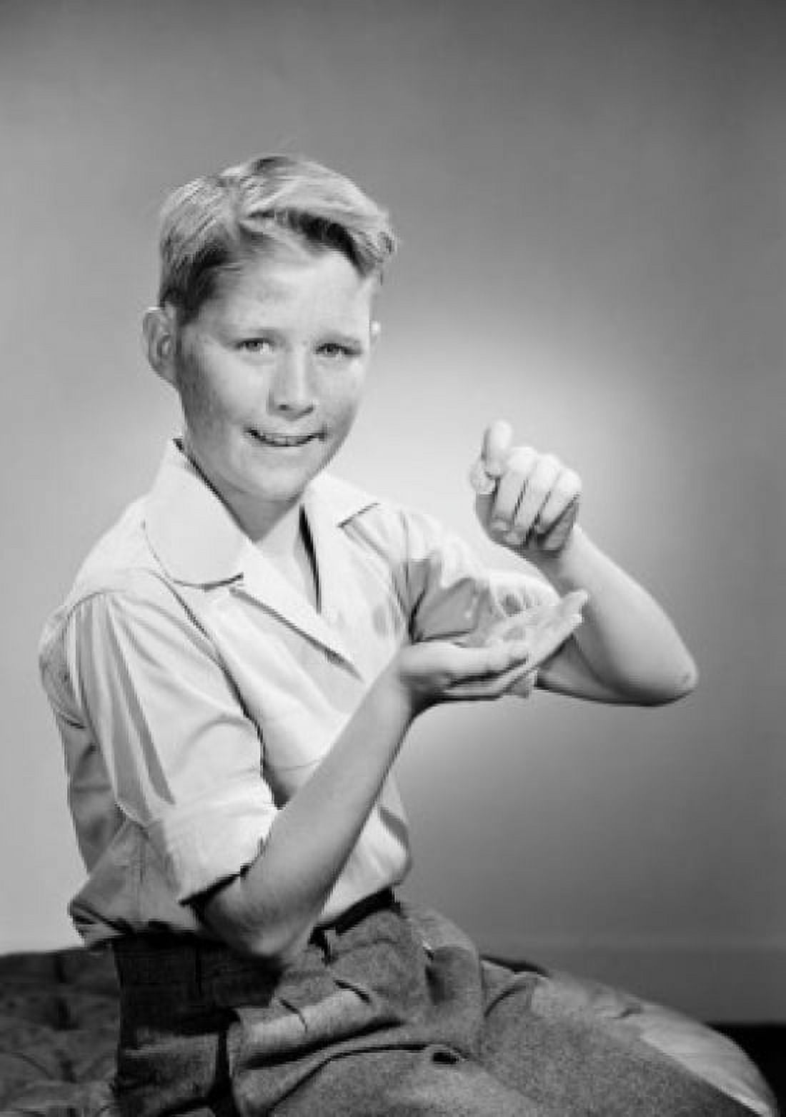 Portrait of boy holding coins and looking at camera Canvas Art - (24 x 36)