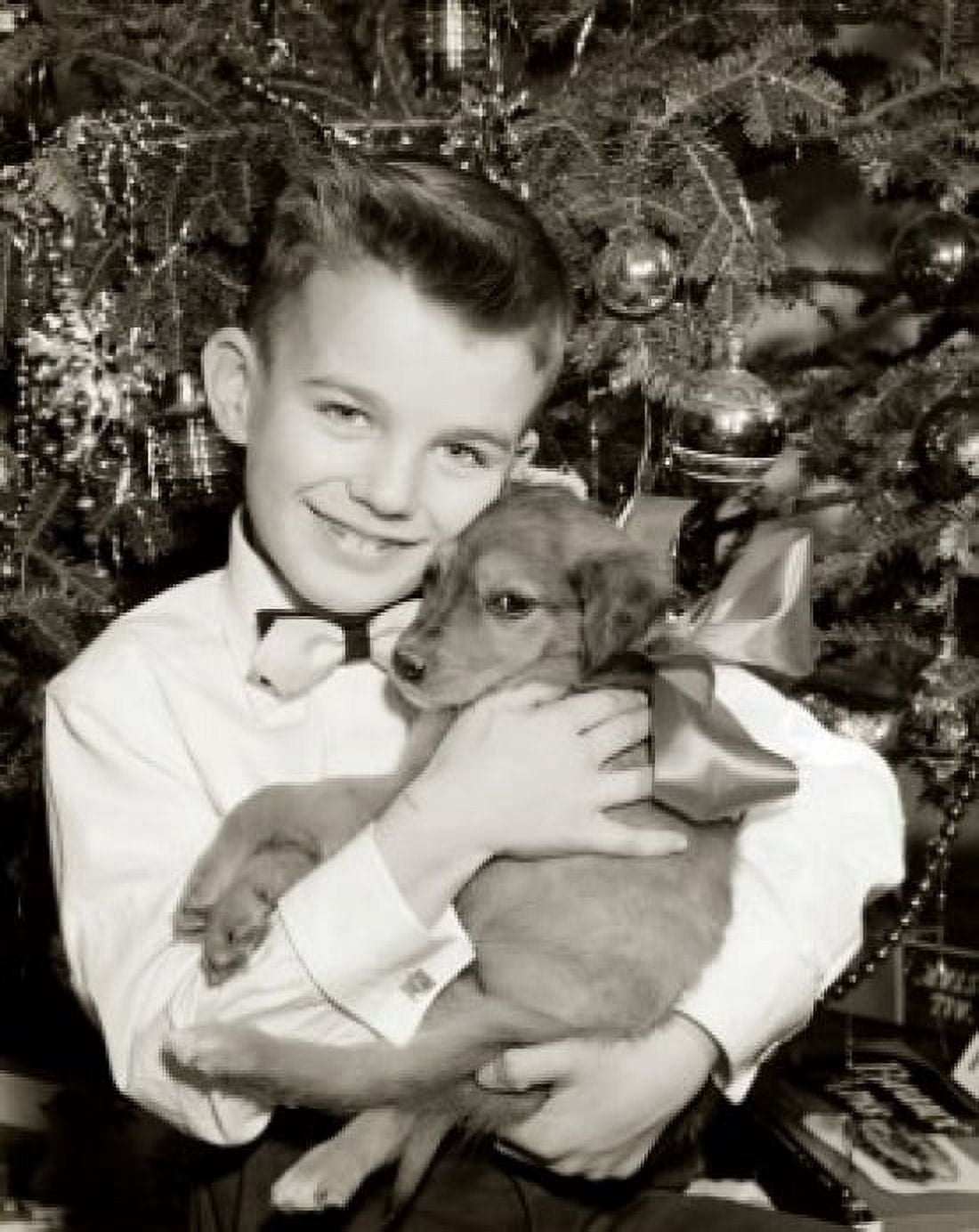 Portrait of boy hugging puppy in front of Christmas tree Canvas Art - (18 x 24)