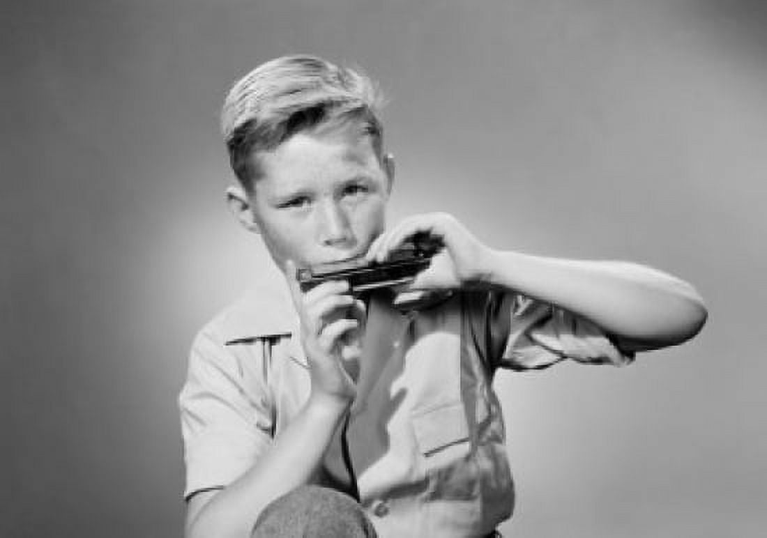 Portrait of boy playing harmonica studio shot Canvas Art - (24 x 36)