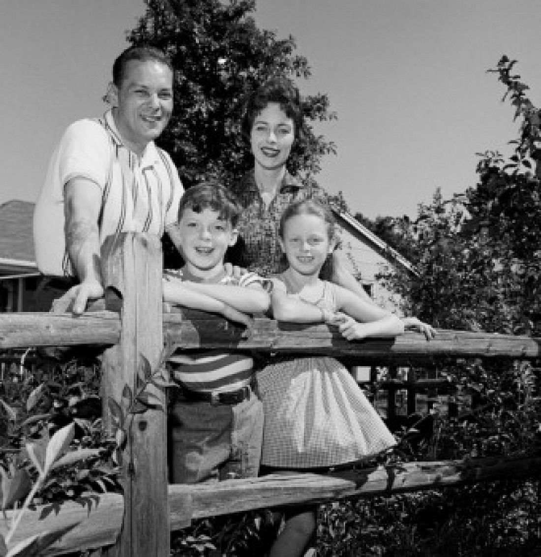 Portrait of parents and kids leaning on farm fence Canvas Art - (18 x 24)
