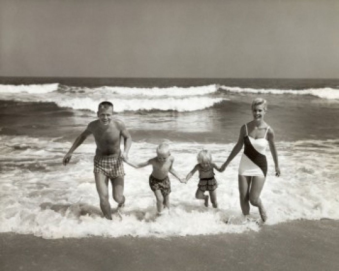 Portrait of parents and their two children running on the beach Canvas Art - (24 x 36)