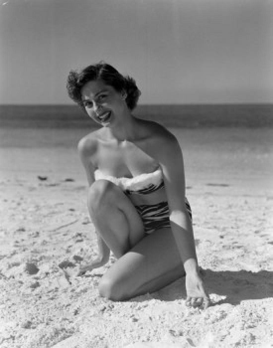 Portrait of pin-up girl wearing bikini crouching on sandy beach Canvas Art - (18 x 24)