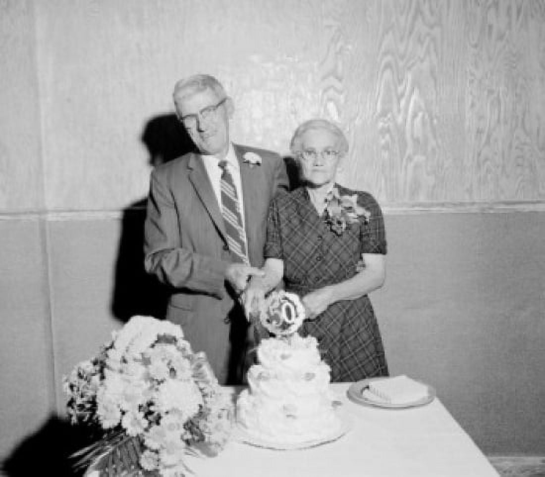 Portrait of senior couple cutting 50th wedding anniversary cake Canvas Art - (24 x 36)