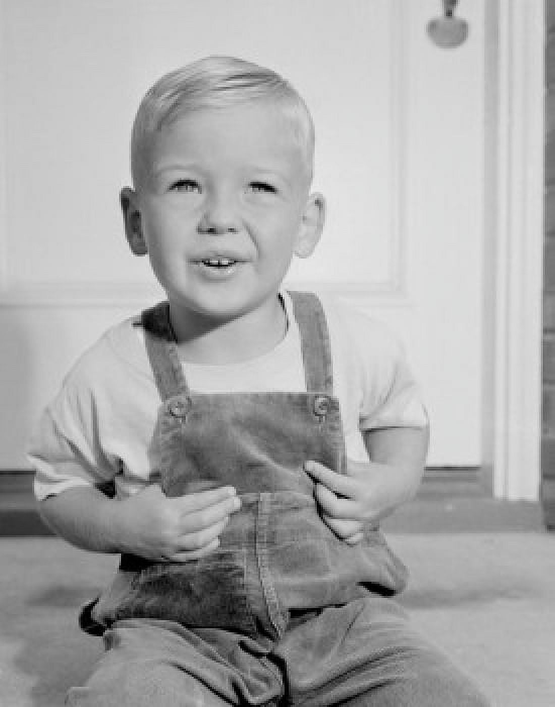 Portrait of small boy in overalls sitting in front of home entrance Canvas Art - (18 x 24)