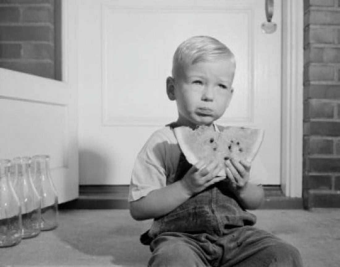 Portrait of small boy sitting in front of home entrance and eating water melon Canvas Art - (24 x 36)