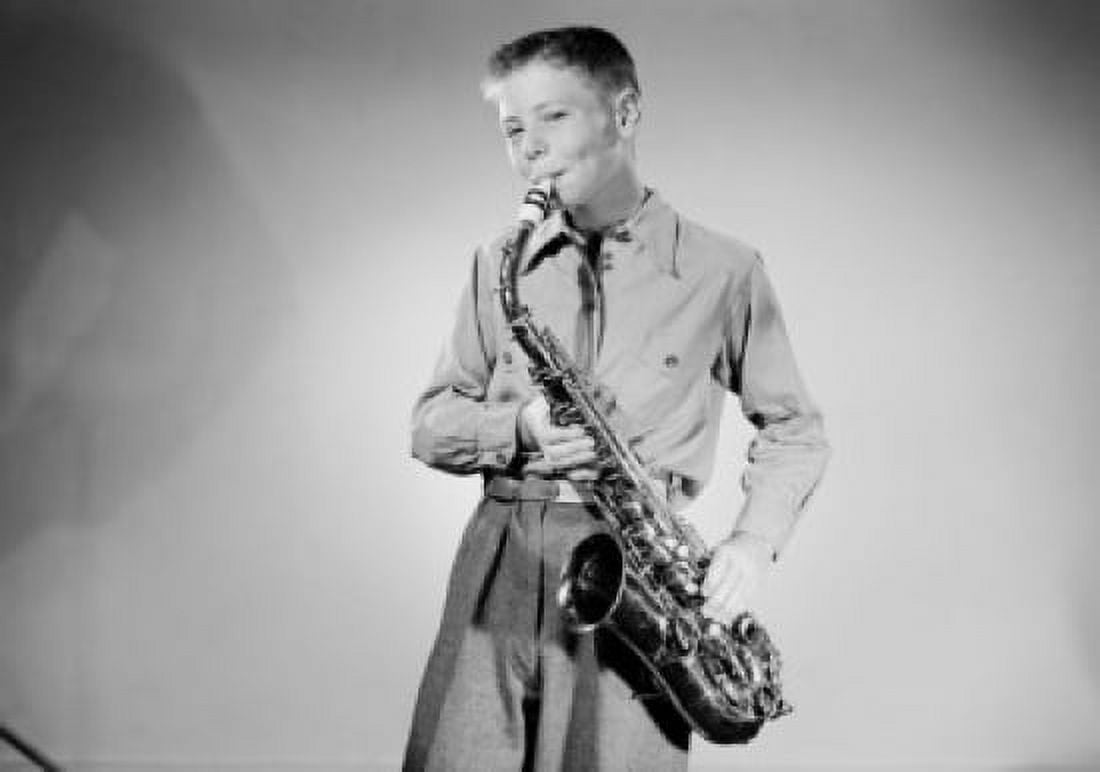 Portrait of smiling teenage boy playing saxophone studio shot Canvas Art - (24 x 36)