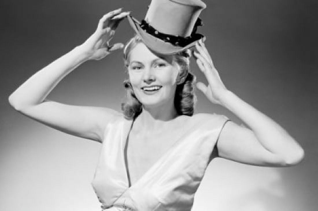 Portrait of smiling woman putting on top hat Canvas Art - (18 x 24)