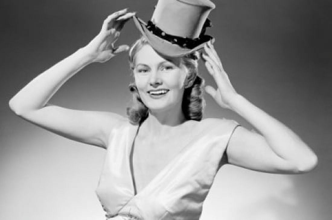 Portrait of smiling woman putting on top hat Canvas Art -  (24 x 36)