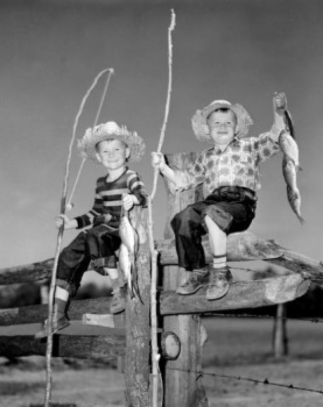 Portrait of two boys with bunch of fish and fishing rods made of sticks sitting on wooden fence Canvas Art - (18 x 24)