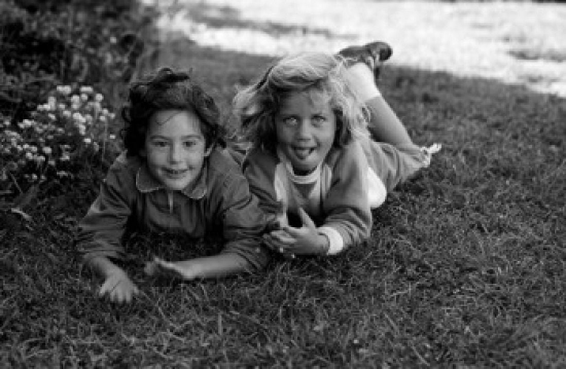 Portrait of two girls lying on lawn Canvas Art - (24 x 36)