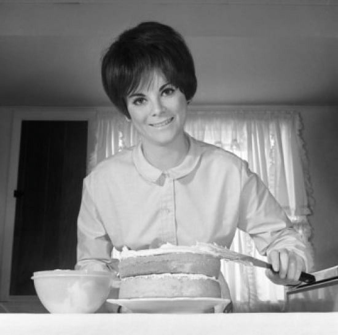 Portrait of woman icing cake in kitchen Canvas Art - (24 x 36)
