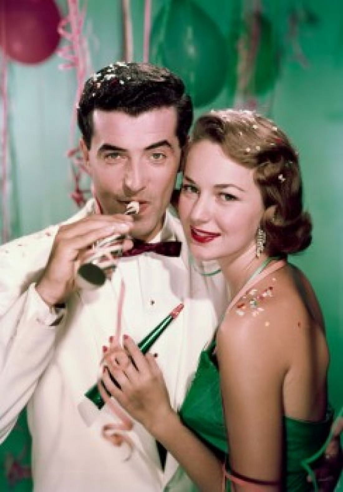 Portrait of young couple with party horn blowers Canvas Art - (18 x 24)