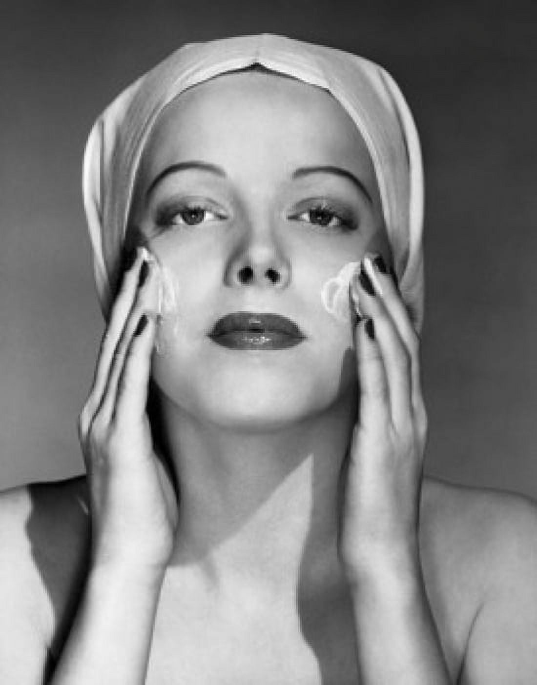 Portrait of young woman applying cream to her face Canvas Art - (18 x 24)
