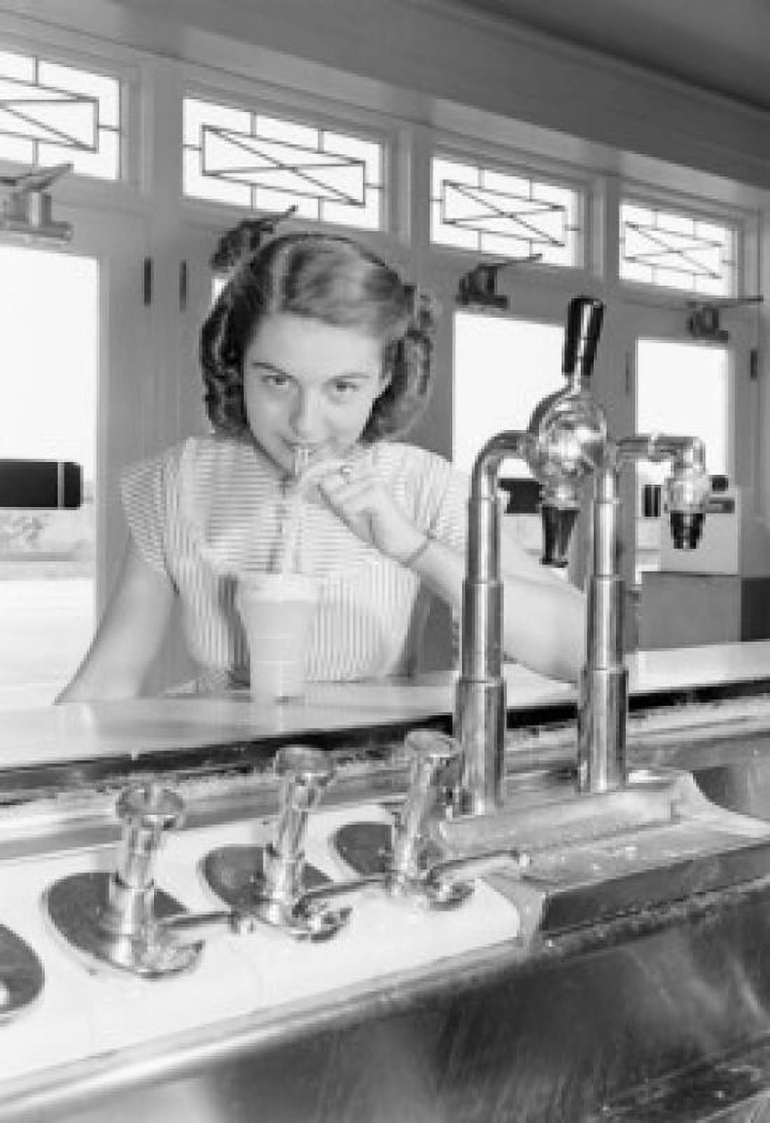 Portrait of young woman drinking milkshake at bar counter Canvas Art - (24 x 36)