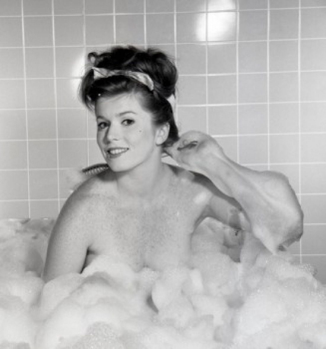 Portrait of young woman scrubbing back in bath Canvas Art - (24 x 36)