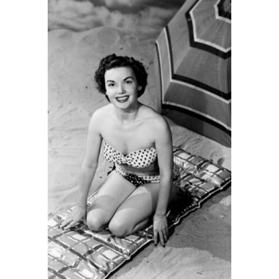 Portrait of young woman sitting on beach Poster Print (18 x 24)