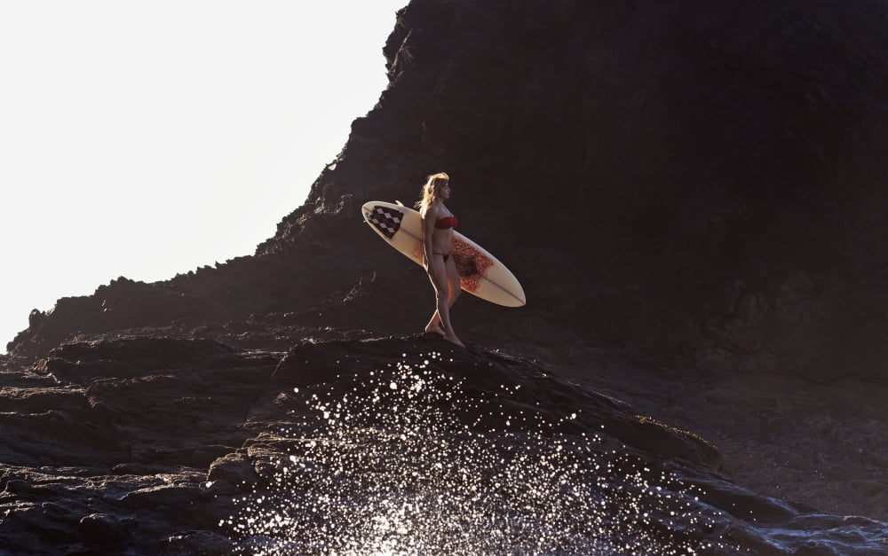 Portugal Algarve Carrapateira Distant View Of Female Surfer With Surfboard Standing On Rock Playa Do Amado Canvas Art - Ben Welsh Design Pics (19 x 12)