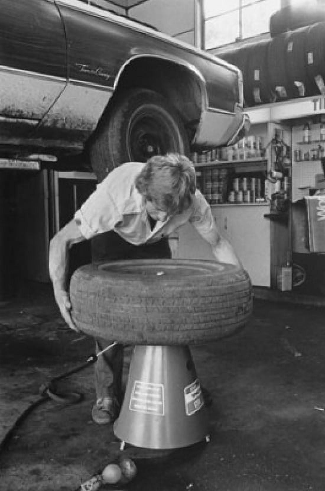 Posterazzi Auto mechanic repairing a tire of a car Canvas Art - (24 x 36)