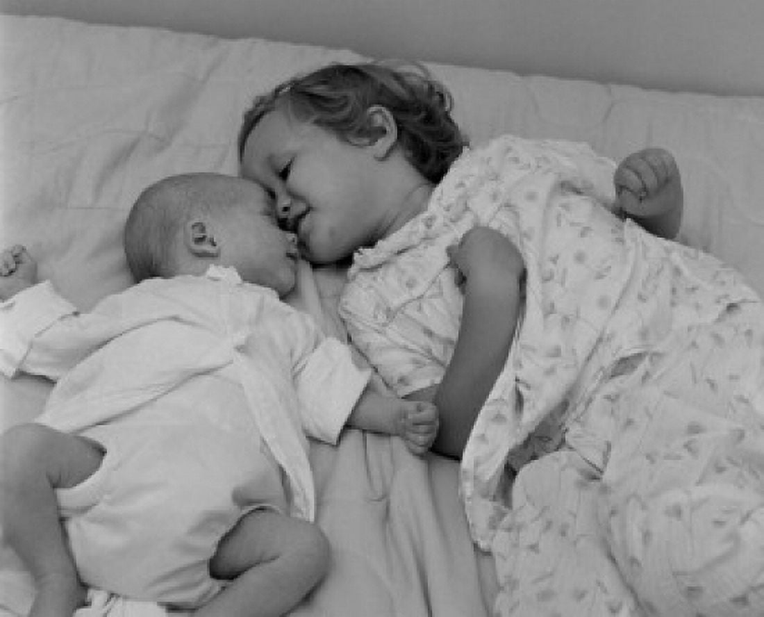 Posterazzi Baby lying with sister on bed Canvas Art - (24 x 36)