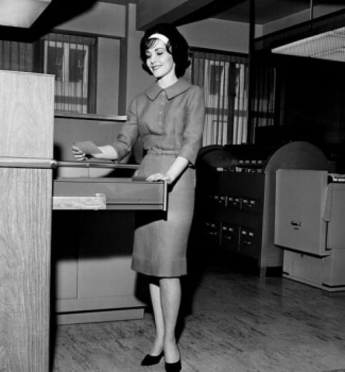 Posterazzi Businesswoman holding a card beside a filing cabinet Canvas Art - (24 x 36)