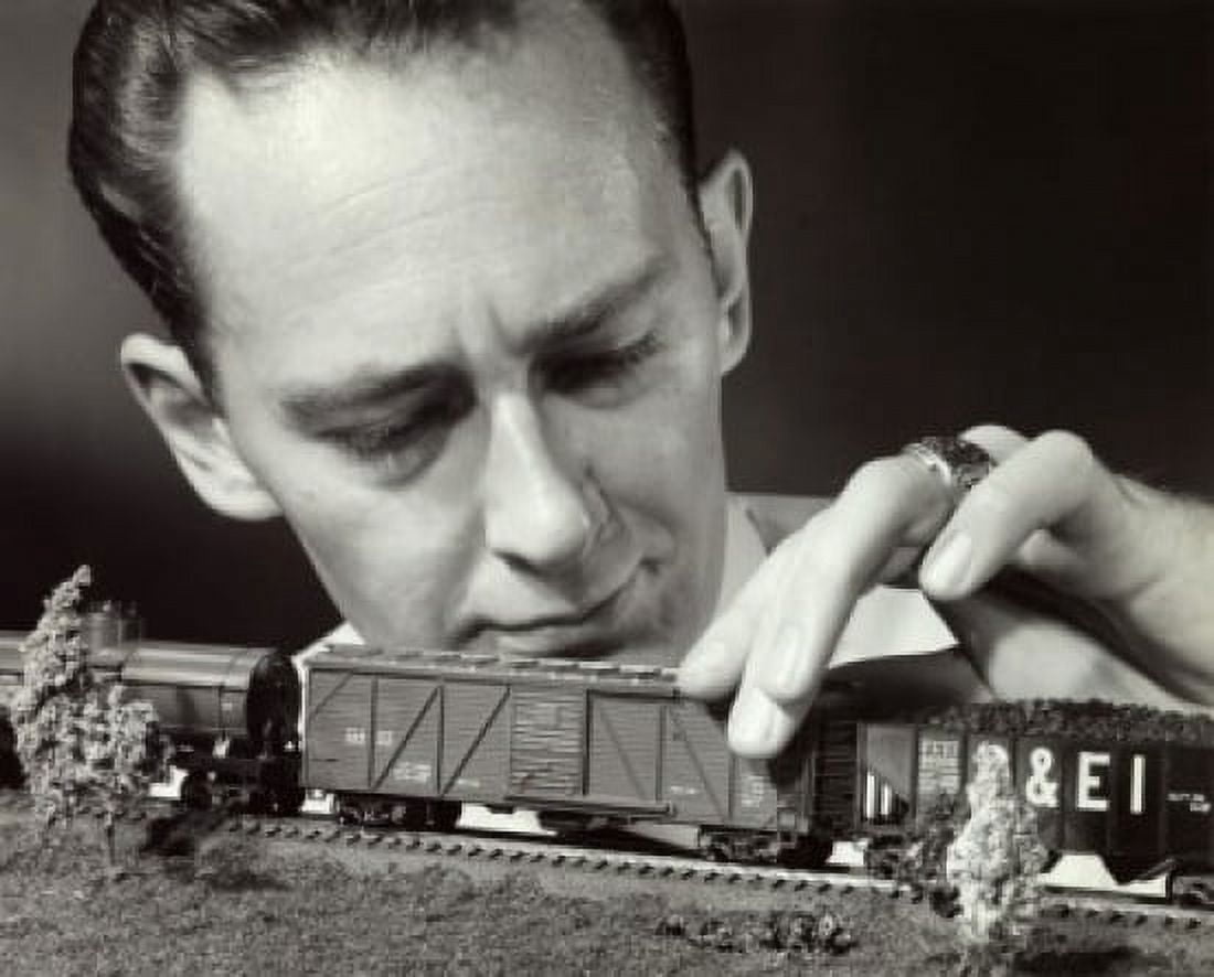 Posterazzi Close-up of a mid adult man holding a model of a toy train Canvas Art - (24 x 36)