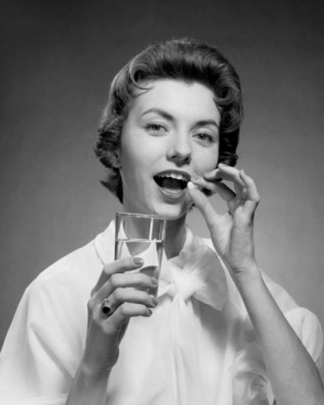 Posterazzi Close-up of a young woman taking a pill Canvas Art - (24 x 36)