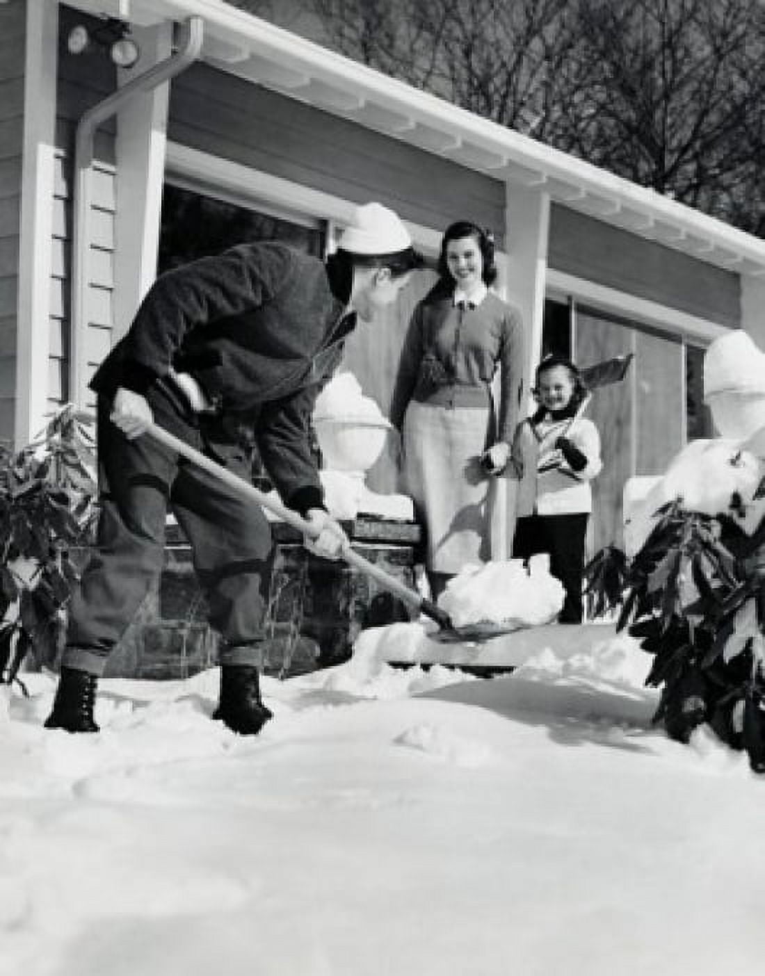 Posterazzi Father removing snow from the front yard of his house and his wife and daughter watching him Canvas Art - (24 x 36)