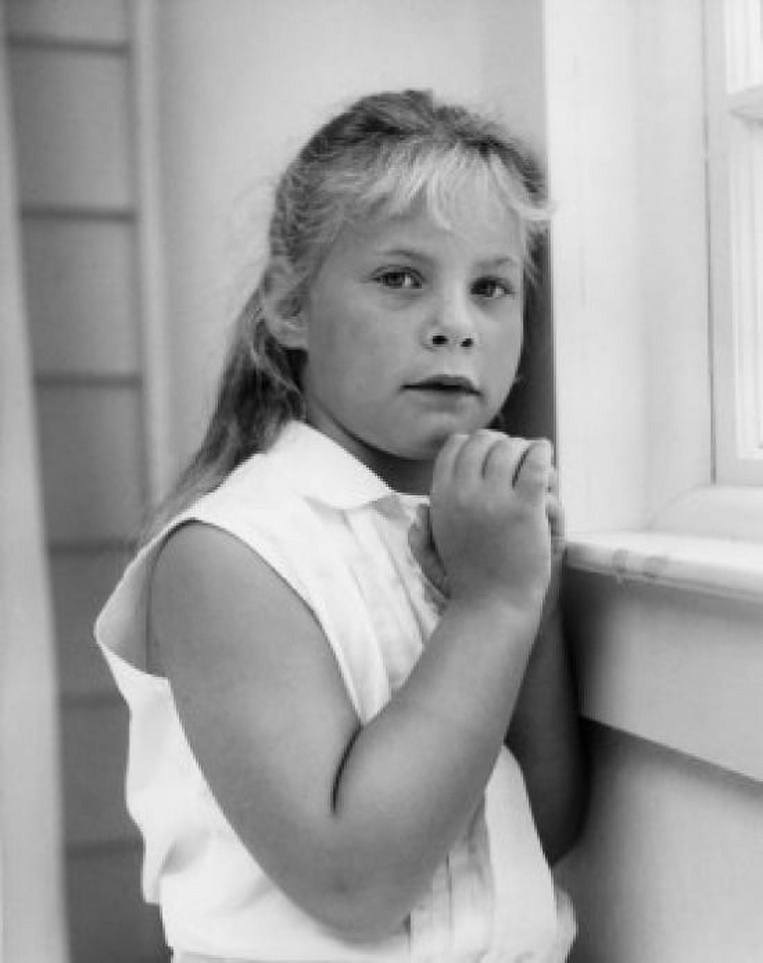 Posterazzi Little girl standing near window with hands folded Canvas Art - (24 x 36)