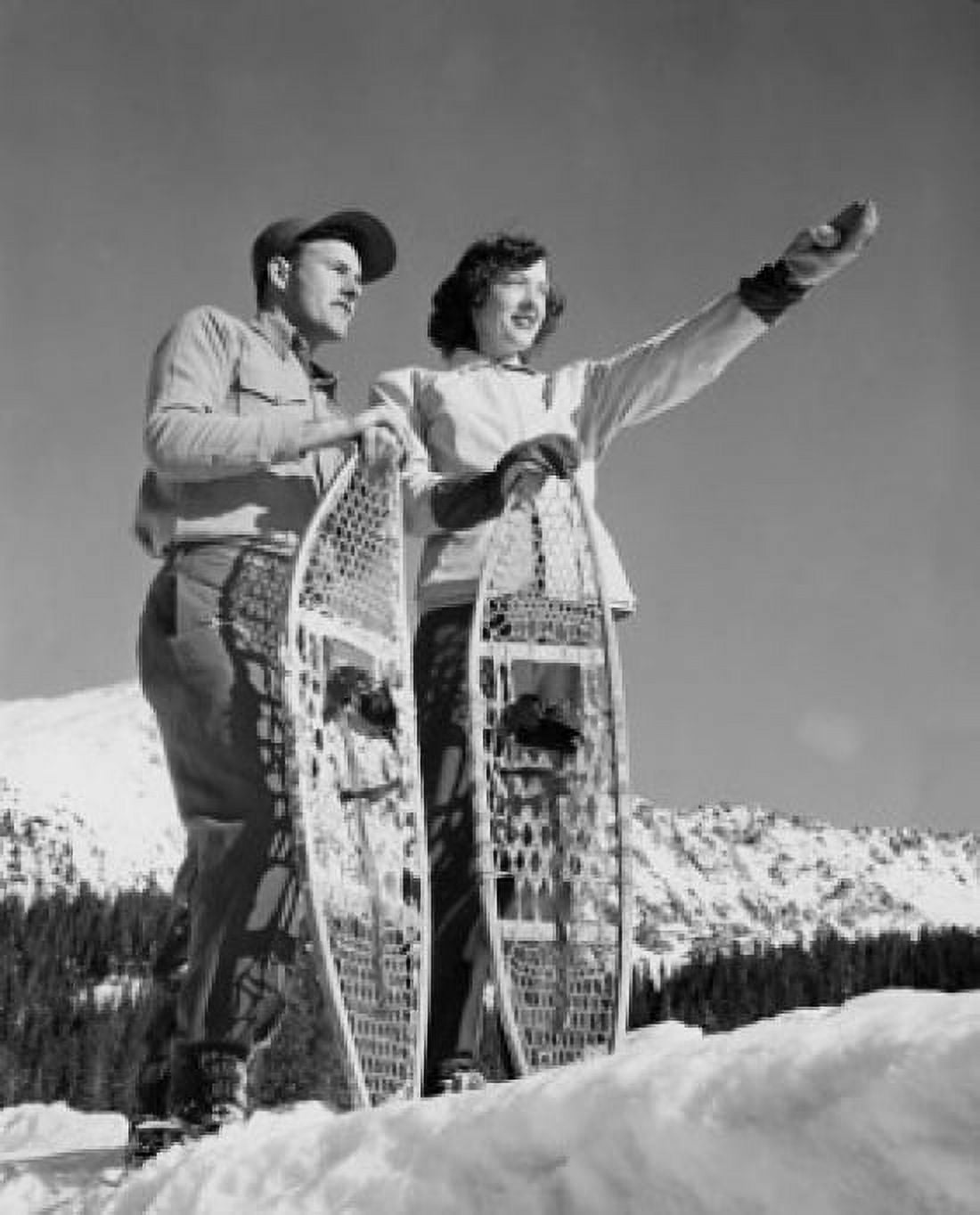 Posterazzi Low angle view of a young couple holding snowshoes Canvas Art - (24 x 36)