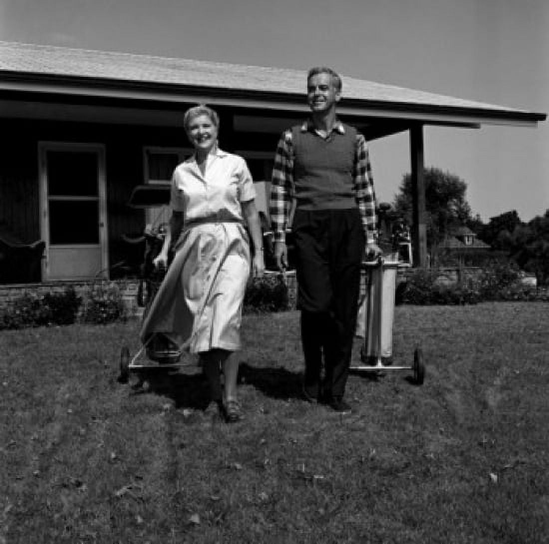 Posterazzi Mature couple pulling carts with golf clubs Canvas Art - (24 x 36)