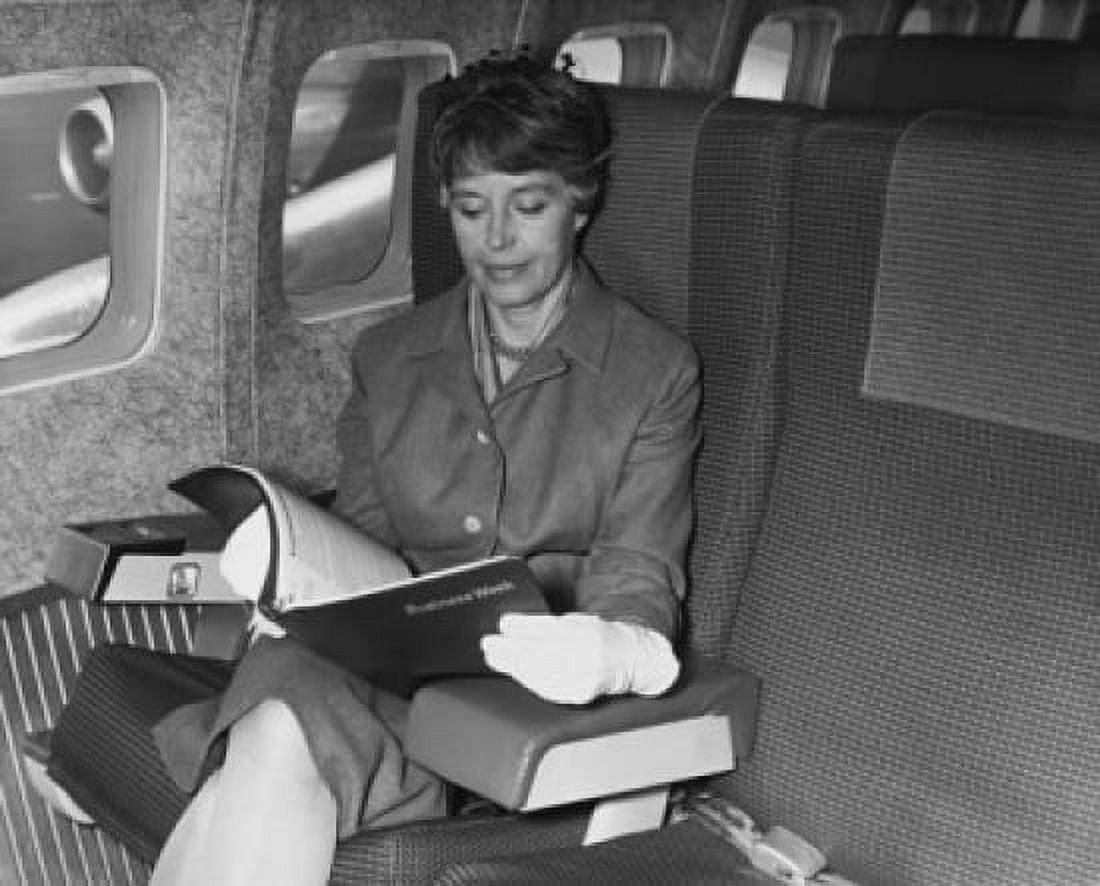 Posterazzi Mature woman sitting on an airplane and reading a magazine Canvas Art - (24 x 36)