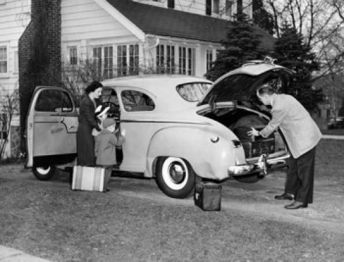 Posterazzi Mid adult couple with their children loading luggage into a car Canvas Art - (24 x 36)
