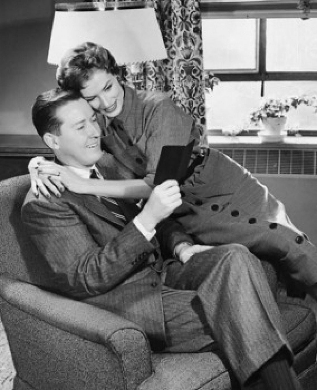 Posterazzi Mid adult man holding a bankbook with a mid adult woman embracing him Canvas Art -  (24 x 36)