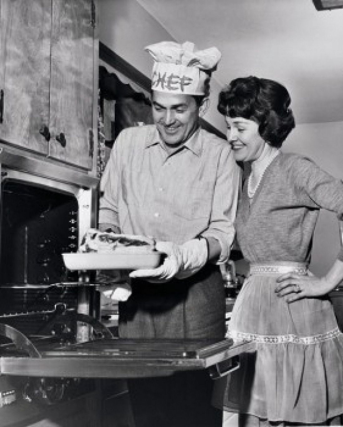 Posterazzi Mid adult man taking food out of an oven with a mid adult woman standing beside him Canvas Art - (24 x 36)