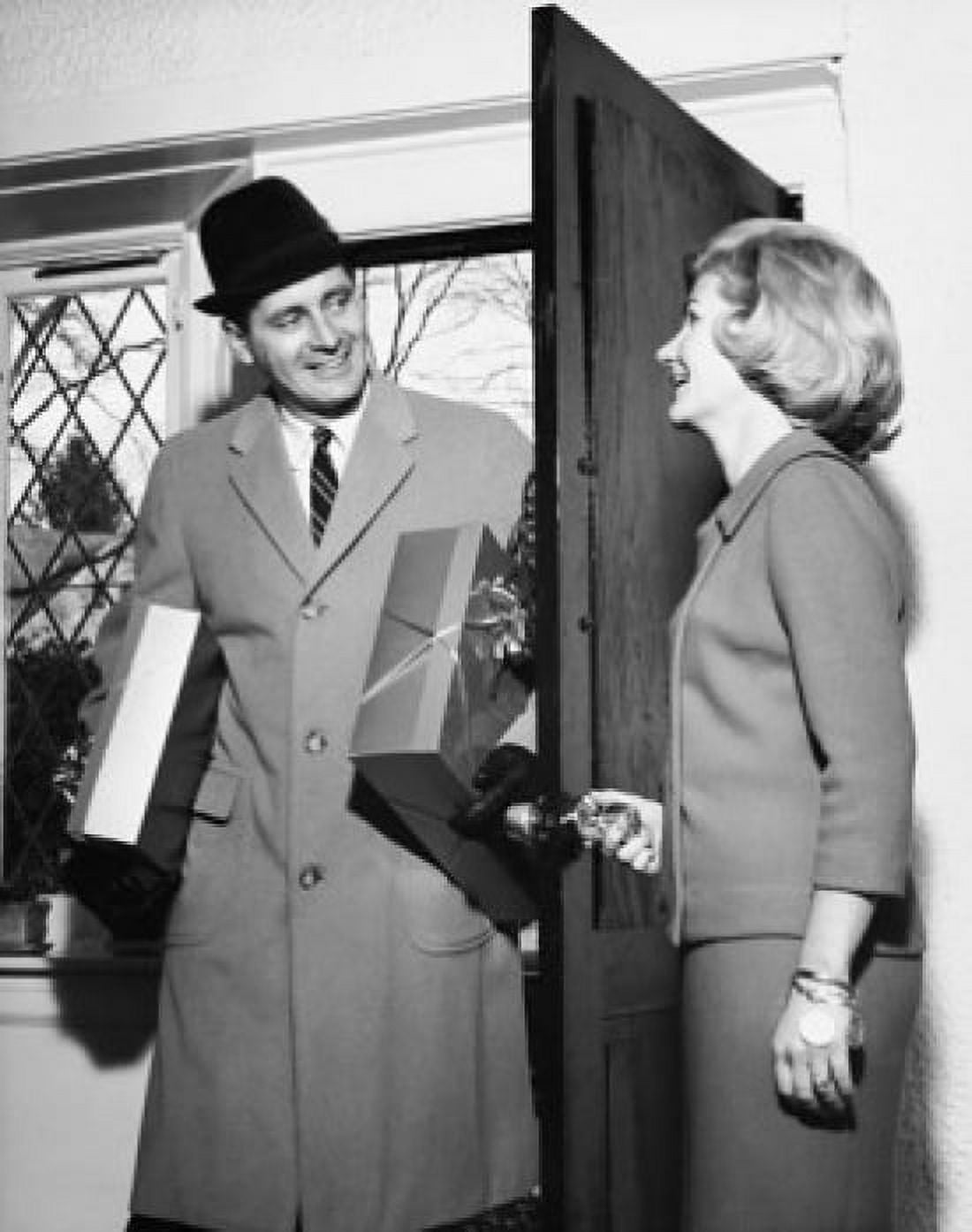 Posterazzi Mid adult woman looking at a mid adult man holding gifts in a doorway Canvas Art - (24 x 36)