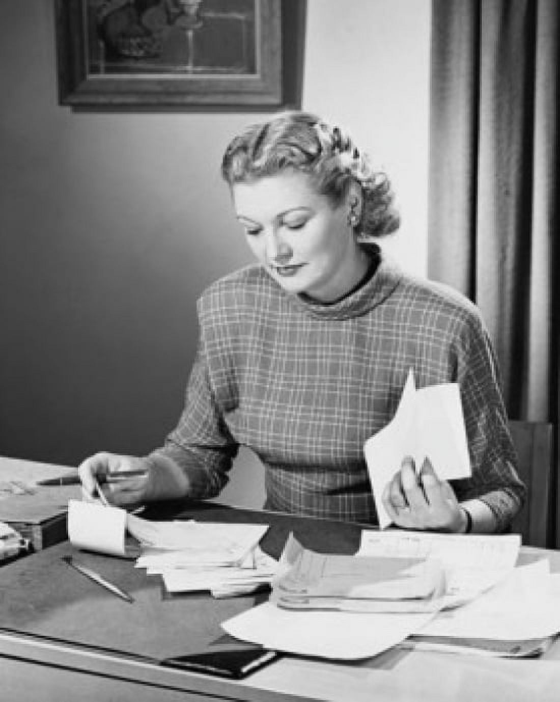 Posterazzi Mid adult woman sitting at a desk and sorting bills Canvas Art - (24 x 36)